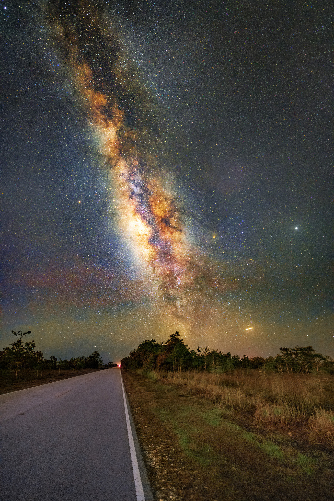The Milky Way arching over a dark road in Everglades National Park