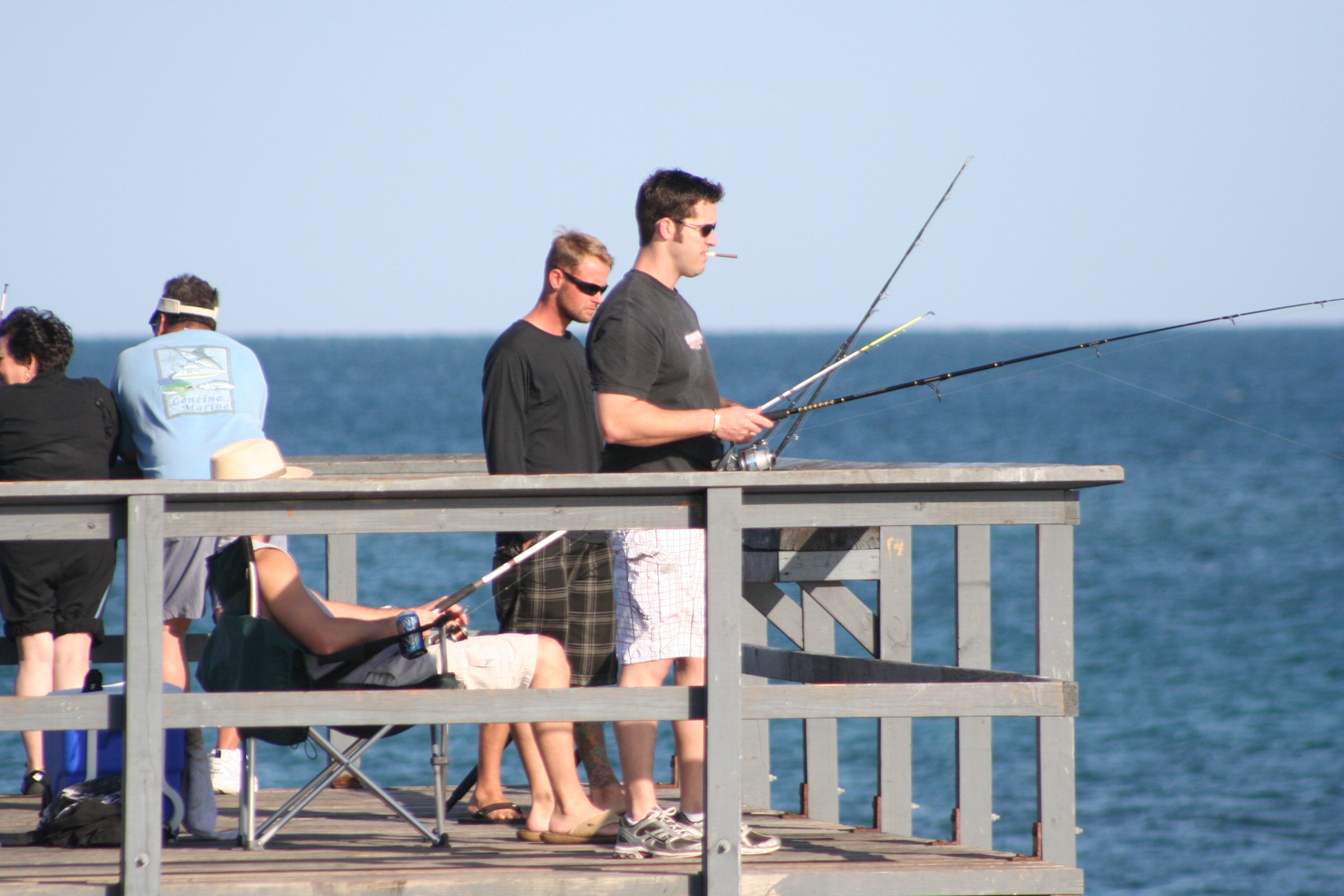 Anglers fishing with rods from Anglin's Fishing Pier in Lauderdale-by-the-Sea, extending into the Atlantic Ocean