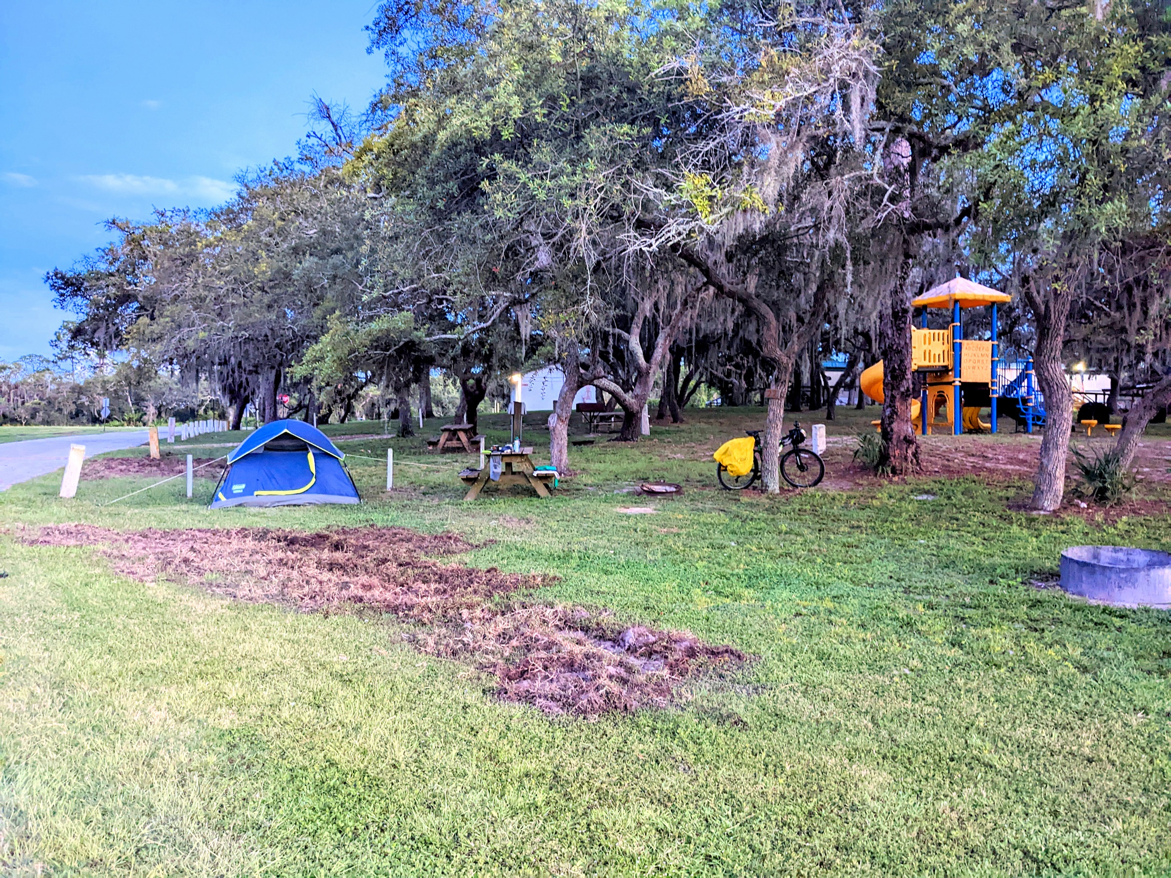 A primitive tent campsite under trees at a Florida campground