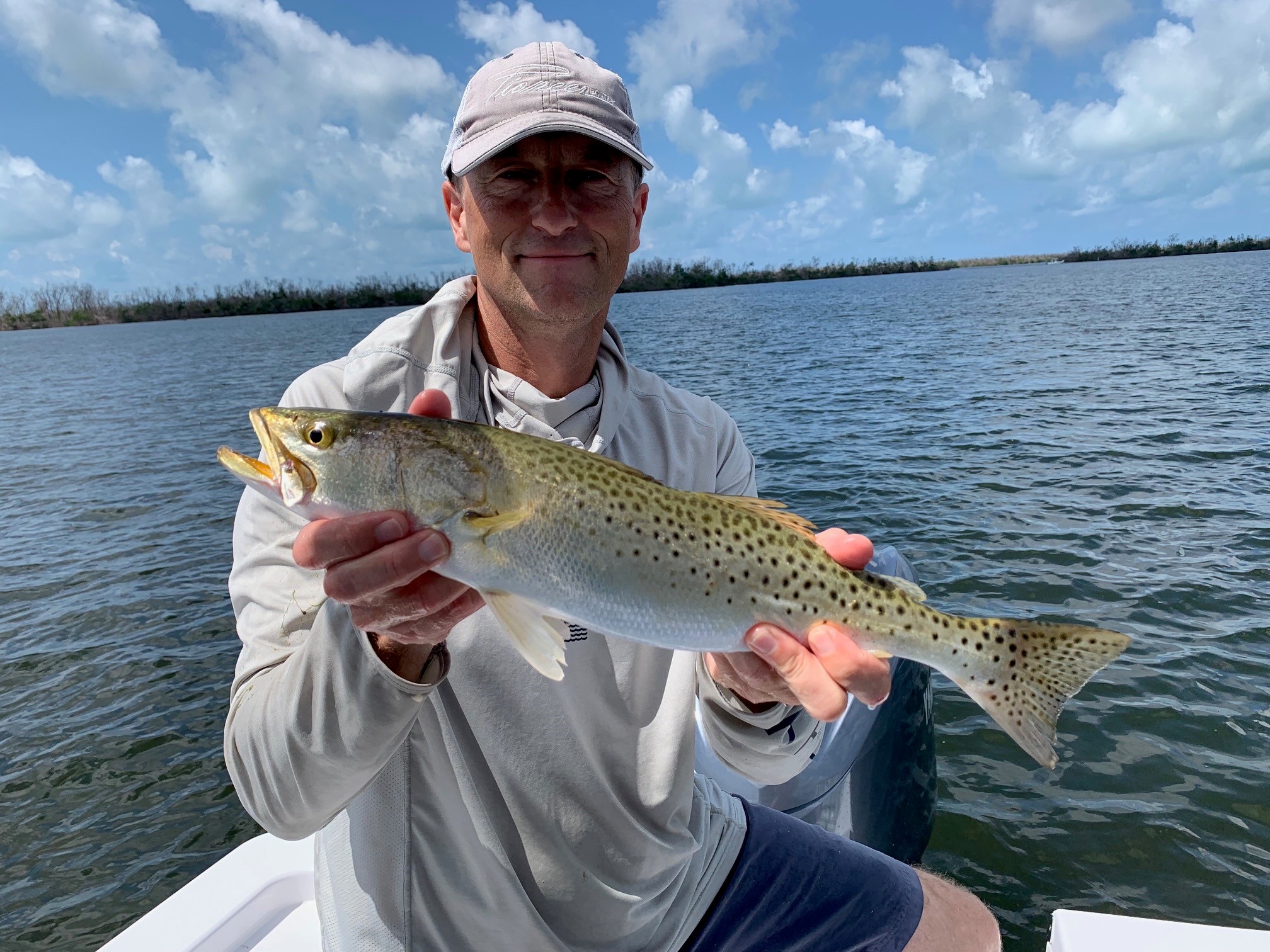 Spotted seatrout (Cynoscion nebulosus) adult specimen showing silvery body with distinctive black spots along the upper flanks, caught in Pine Island Sound, Florida