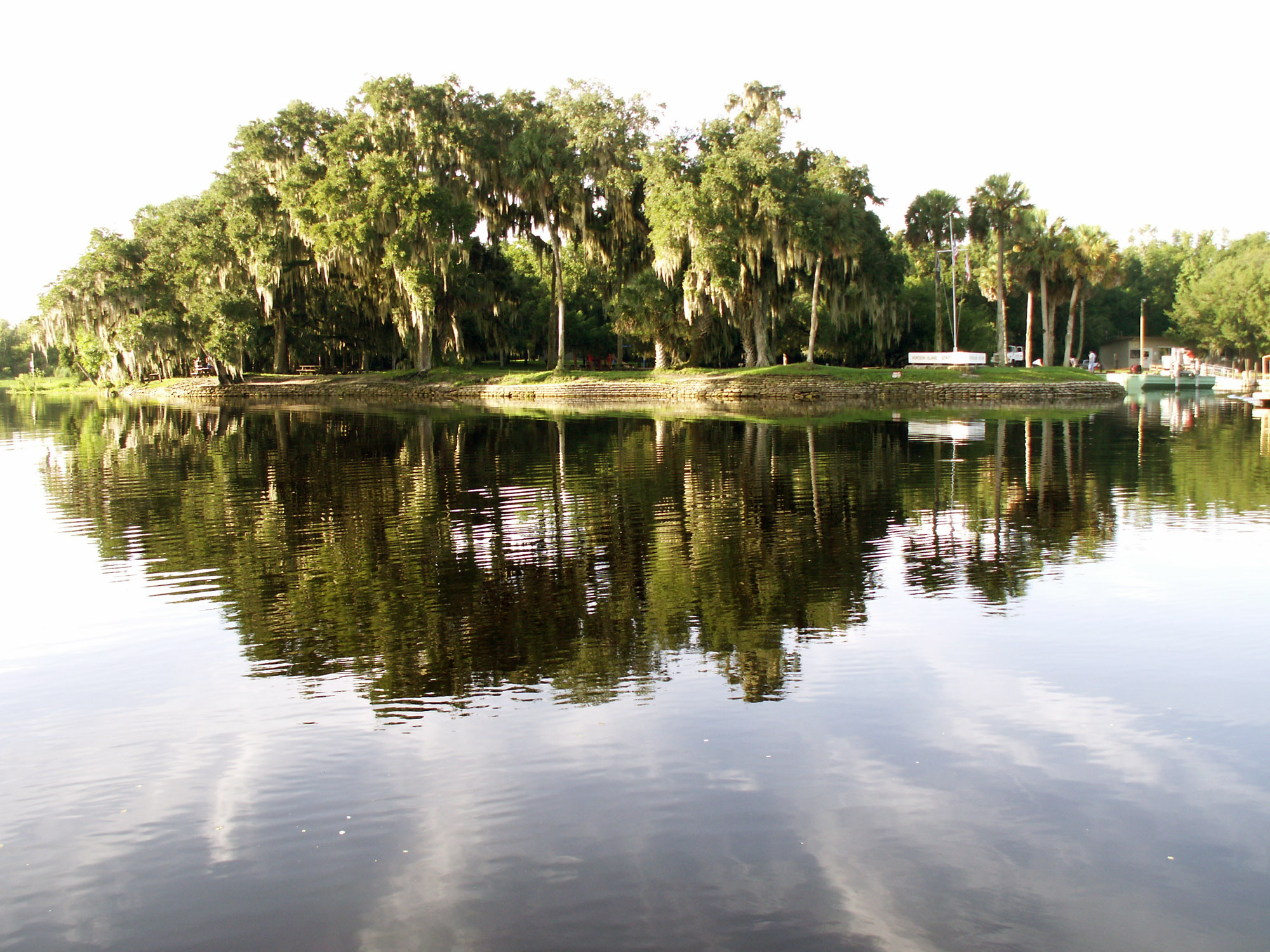 A calm, glassy stretch of the St. Johns River with moss-draped trees at Hontoon Island State Park